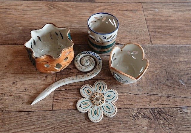 Von Hand bemalte Keramikstücke: Windlichter, Schalen und ein Blumenuntersetzer